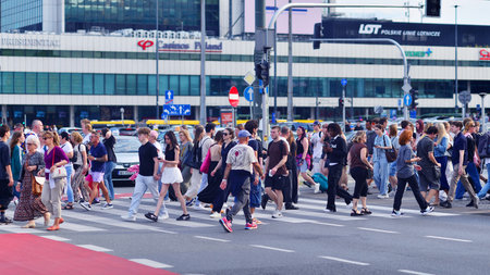 Warsaw, Poland. 5 August 2025. People of different ages crossing the road through. Somer street of a...