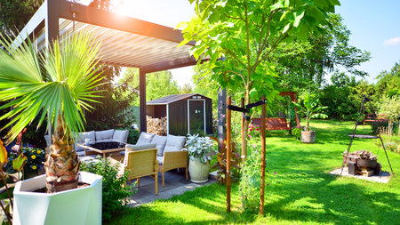 Modern aluminum pergola with stylish garden furniture in a beautiful garden.