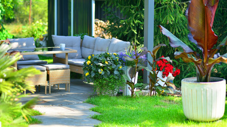 Modern aluminum pergola with stylish garden furniture in a beautiful garden.