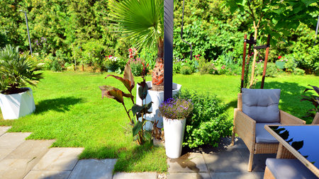 Modern aluminum pergola with stylish garden furniture in a beautiful garden.