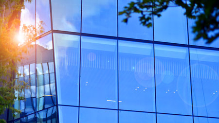 Sustainable glass office building with trees for reducing carbon dioxide. Eco-friendly building in...