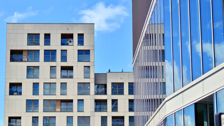 View of an modern apartment building standing next to a new modern office building with a glass...