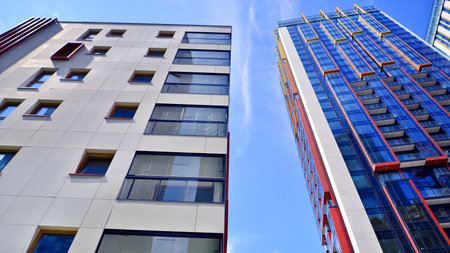Exterior of a high modern multi-story apartment building - facade, windows and balconies. Timeless...