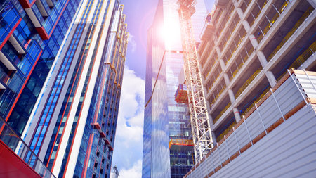 Crane on the construction site in a site surrounded by the high buildings. Office building under...