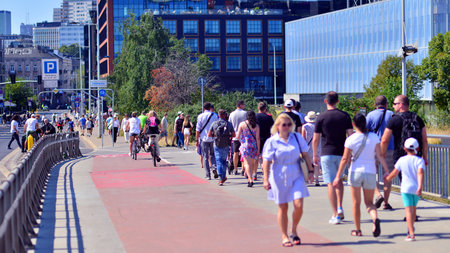 Warsaw, Poland. 15 August 2025. Tourists and residents crossing crowded Swietokrzyski Bridge. Groups...