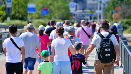 Warsaw, Poland. 15 August 2025. Tourists and residents crossing crowded Swietokrzyski Bridge. Groups...