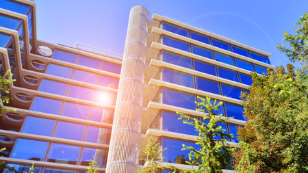 Modern luxury office building.The structure features a glass and concrete walls, showcasing contemporary architecture. The green surroundings of office buildings. Trees and shrubsの写真素材