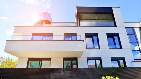 Modern luxury apartment building with balconies.The structure features a glass wall in front, showcasing contemporary architecture.の写真素材