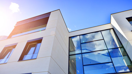 Modern luxury apartment building with balconies.The structure features a glass wall in front,...