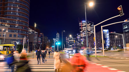 Warsaw, Poland. 4 November 2025. Blurred people cross a street at a crosswalk in center city in the...