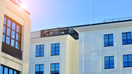 Office building in loft style. Facade of commercial office with windows. White walls of an...