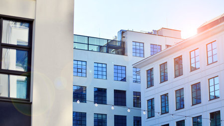 Office building in loft style. Facade of commercial office with windows. White walls of an...