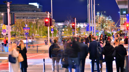 Warsaw, Poland. 4 November 2025. Blurred people cross a street at a crosswalk in center city in the...