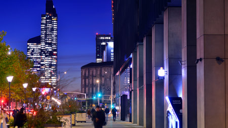 Warsaw, Poland. 4 November 2025. People walk along the sidewalks at night. Lights street and...