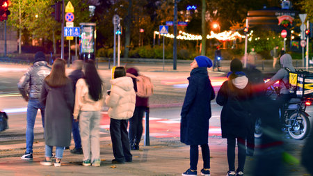Warsaw, Poland. 4 November 2025. Blurred people cross a street at a crosswalk in center city in the...