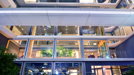Modern office building in city center illuminated at night. Rows of lit windows against the...