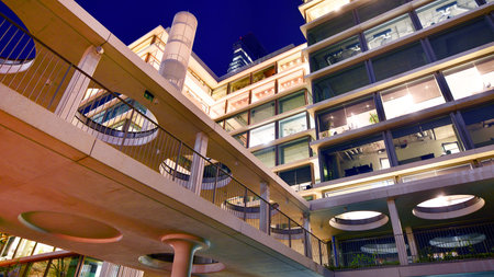 Modern office building in city center illuminated at night. Rows of lit windows against the...