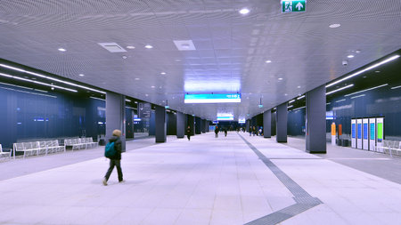 Warsaw, Poland. 28 November 2025. Commuters going through the underground passage hall at Warszawa Zachodnia train station. Ceiling mounted large artificial illumination.のeditorial素材