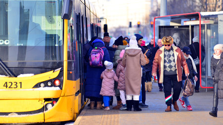 Warsaw, Poland. 5 January 2026. Modern yellow tram urban european city center with public transit stop.のeditorial素材