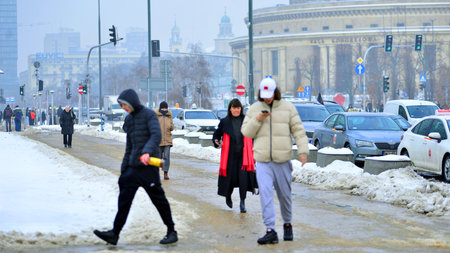 Warsaw, Poland. 15 January 2026. People walking on the street in the city on a winter cold day. Crowd of anonymous people walking on busy street. Urban street life.のeditorial素材