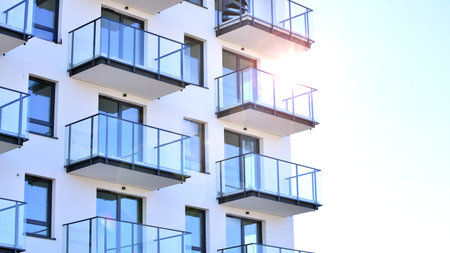 Modern apartment buildings on a sunny day with a blue sky. Facade of a modern apartment building. Glass surface with sunlight.