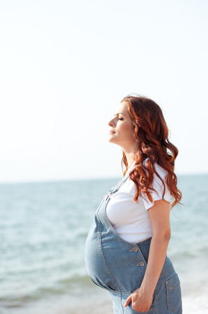 Pregnant woman resting at sea shore outdoors. Young adults. Motherhood. Maternity.の写真素材
