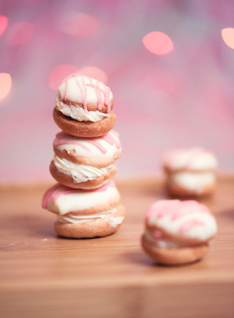 Stack of tasty cakes with cream cheese over colorful lights closeup. Selective focus.の写真素材