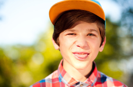 Young kid boy 14-16 year old having fun closeup outdoors. Looking at camera. Childhood. の写真素材