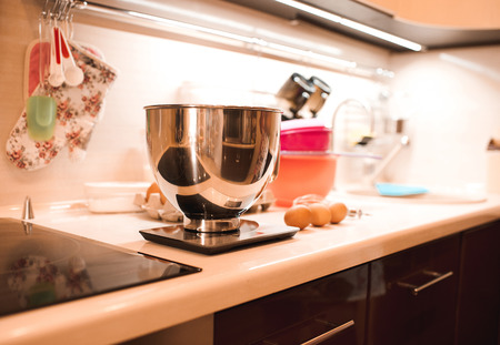 Cooking process. Weighting in metal bowl on kitchen scales closeupの写真素材