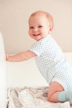 Smiling baby boy in bed. Looking at camera. Happiness. Healthy child. の写真素材