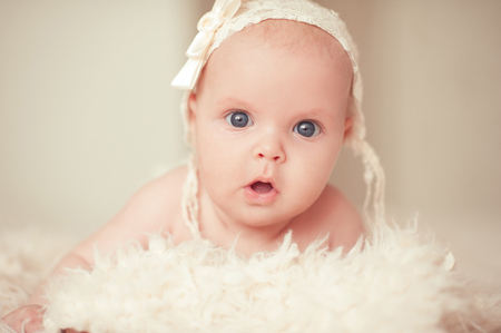 Cute surprised baby lying in bed. Looking at camera. Childhood.の写真素材