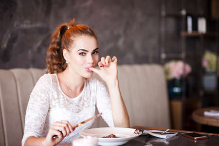 Cute woman eating tasty food in cafe closeup.