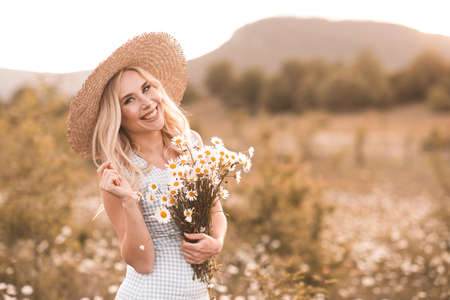 Beautiful young with blond hair girl 24-25 year old wearing straw hat holding fresh natural...