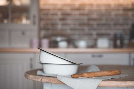 Vintage cooking bowls with rolling pin on kitchen table closeup. Rustic style.の写真素材