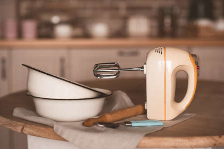 Vintage mixer with cooking bowls and rolling pin on kitchen table closeup.の写真素材
