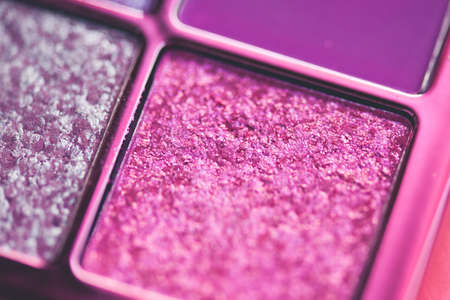 Make up palette with pink glitter eye shadows in box closeup. Beauty producs. Selective focus.