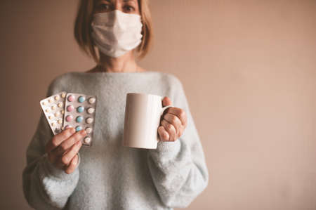 Adult woman wearing medical mask closeup. Looking at camera. Home quarantine. European.