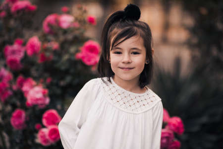 Happy child girl 3-4 year old holding pet dog over nature background closeup. Looking at camera. Selective focus on puppy. Summer season.の写真素材