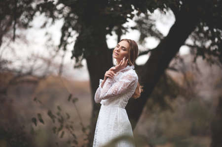 Beautiful lady girl 22-24 year old wearing vintage white dress outdoors. Wedding day. 20s. Celebrationの写真素材