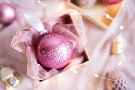 Cute pink Christmas ball in box closeup. Winter holidays. Top view.の写真素材