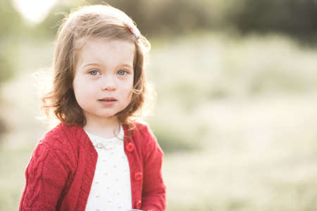 Smiling baby girl 2-3 year old eating fresh ripe strawberry outdoors closeup. Happiness. Healthy lifestyle.の写真素材