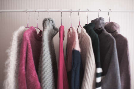 Open shop with rack of knitted sweaters closeup. Winter season.