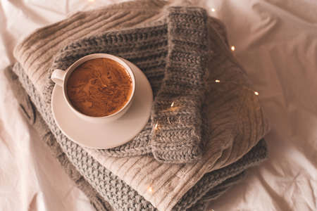 Winter holiday season concept: cup of fresh coffee on knitted sweaters close up. Good morning.の写真素材