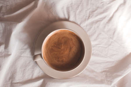 Cup of coffee over white background on table close up. Top view. Good morning. Breakfast time.