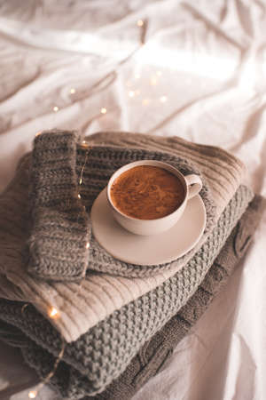 Cup of coffee staying on knitwear close up. Winter holiday season. Good morning.の写真素材