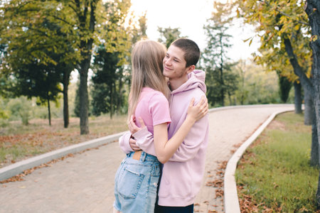 Smiling teenage couple wear casual clothes holding together outdoor in park. relationship.の写真素材
