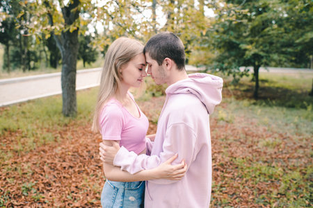 Two teenage girl and boy 16-17 year old wearing casual clothes hold each other with closed eyes in...