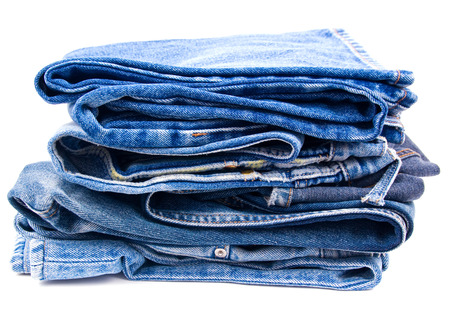 Pack of worn blue jeans isolated on whiteの写真素材
