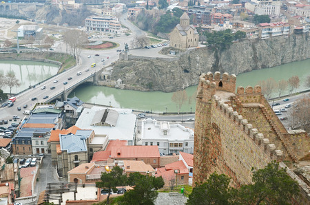 View of Metekhi Bridge and Assumption Church from the wall of Narikala fortress in cloudy day....