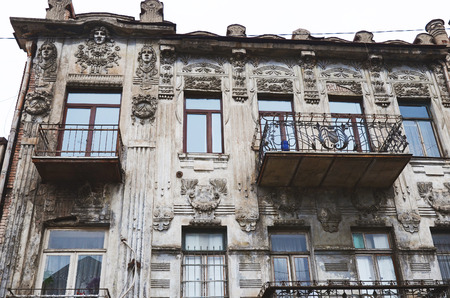 Facade sculpture on an old apartment building with wrought balconies in Tbilisi Georgiaのeditorial素材